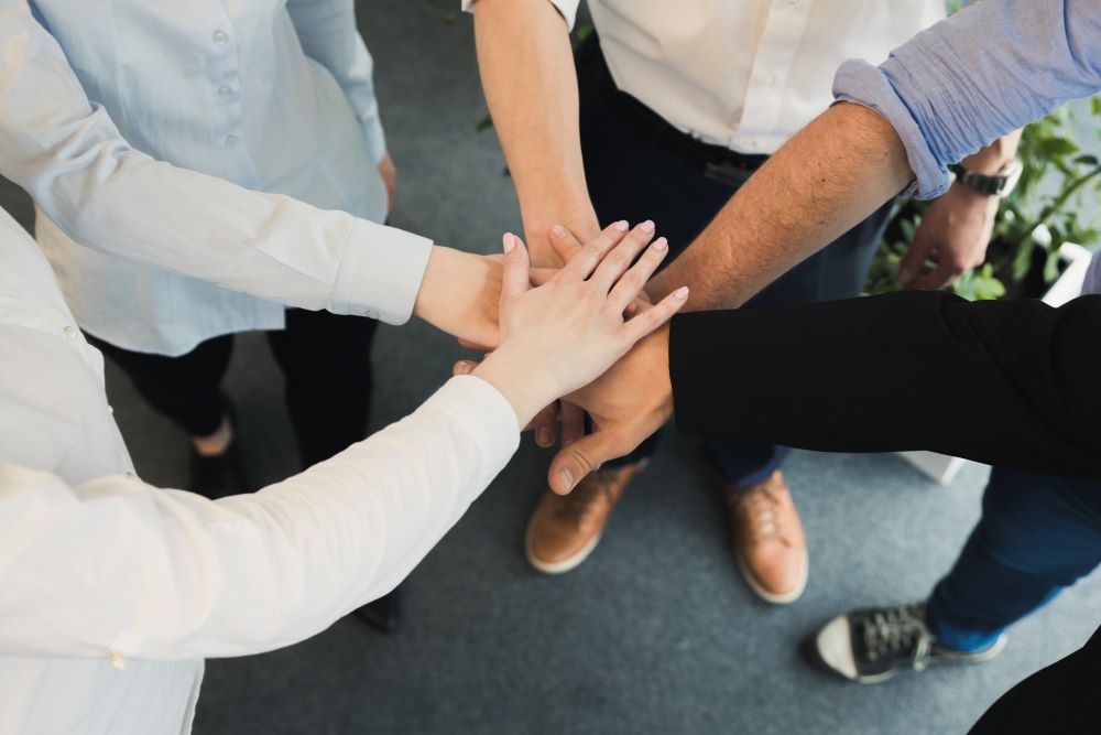Team gestapelte-hande-von-oben
